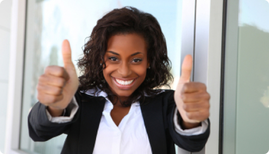A woman in a corporate setting with both her thumbs up